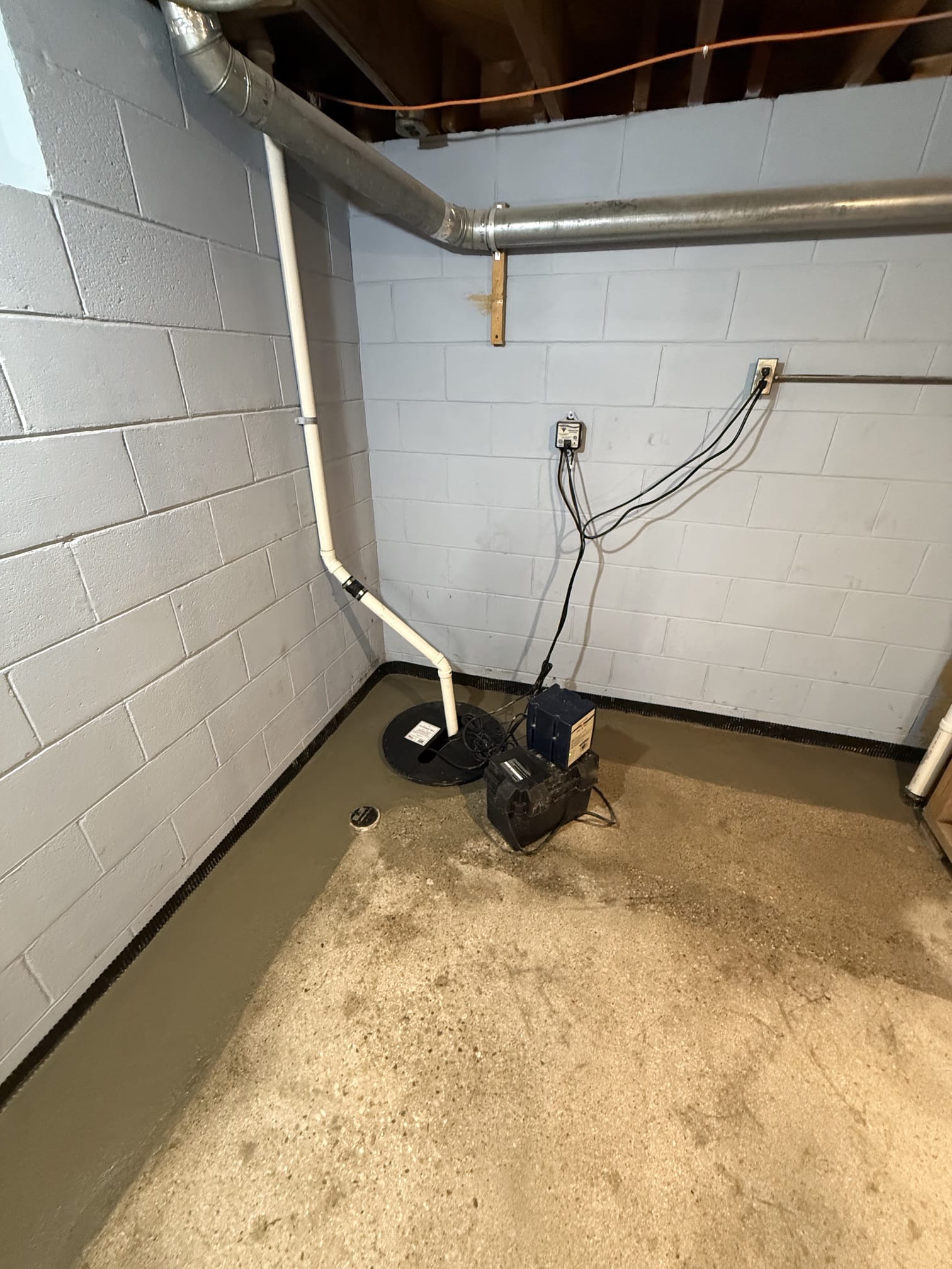 After — a dry, sealed basement with a new sump pump and battery backup installed by Basement Foundation Repair